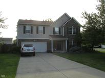 Inviting two-story home with a brick and vinyl exterior and a well-manicured front yard at 10443 Ringtail Pl, Fishers, IN 46038