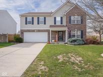 Charming two-story home with a well-manicured lawn, attached garage, and tasteful fall decorations at 10443 Ringtail Pl, Fishers, IN 46038