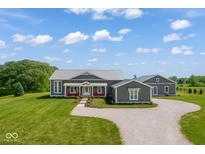 Beautiful exterior with a metal roof, wraparound porch, meticulous landscaping and a circular drive on a large lot at 10655 E 200 S, Zionsville, IN 46077