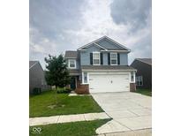 Charming two-story home with a two-car garage, tree in the front yard, and light blue siding at 10835 Spirit Dr, Ingalls, IN 46048