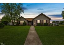 Charming single-story home with well-manicured lawn and inviting walkway at 1202 Orphant Annie, Greenfield, IN 46140