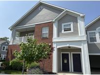 Charming brick and siding townhome with covered porch and blue doors under a clear blue sky at 1280 Shadow Ridge Rd, Indianapolis, IN 46280