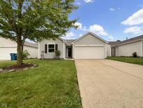 Charming single-story home with a well-maintained lawn and attached two-car garage on a sunny day at 13094 N Etna Green Dr, Camby, IN 46113