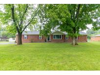 Charming brick home featuring a well-maintained lawn and mature trees at 1514 Bittersweet Dr, Greenfield, IN 46140