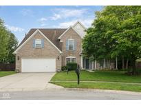 Charming two-story brick home featuring an attached two-car garage and a cozy front porch, set on a well-manicured lawn at 15409 Heath Cir, Westfield, IN 46074