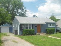 Charming single-story home with blue siding, mature landscaping, and detached garage at 1732 N Ritter Ave, Indianapolis, IN 46218