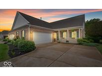 Charming brick home with an attached garage, inviting front porch, and well-manicured landscaping at 1905 Persimmon Grove Dr, Indianapolis, IN 46234