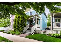 Charming two-story home with a light blue exterior, a welcoming porch, and a lush, landscaped front yard at 2017 Rhettsbury St, Carmel, IN 46032