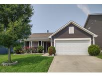 Inviting single-story home with manicured lawn, flowering bushes, and a two-car garage at 2432 Bridlewood Dr, Franklin, IN 46131