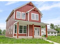 Inviting two-story home featuring a charming front porch and well-manicured lawn on a sunny day at 2903 Winthrop Ave, Indianapolis, IN 46205