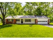 Charming single story brick home with an attached garage and a covered front porch at 4275 Springwood Trl, Indianapolis, IN 46228