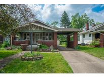 Charming craftsman home featuring a brick facade, covered porch, and well-manicured lawn at 5133 E Michigan St, Indianapolis, IN 46219