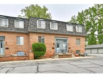 Charming brick two-story townhome with landscaped yard and a welcoming blue front door at 5153 Brendonshire Ct, Indianapolis, IN 46226