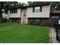 Split-level home featuring neutral siding, brick accents, and a well-maintained green lawn at 7402 Broadview Dr, Indianapolis, IN 46227