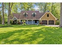 Charming two-story home with a well-manicured lawn, blue siding, stone accents, and a three-car garage at 7630 Blain Way, Indianapolis, IN 46254