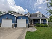Charming blue two-story home with a landscaped front yard and an attached two-car garage at 802 Fern Dr, Shelbyville, IN 46176