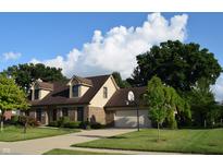 Charming two-story brick home with a well-maintained lawn, a basketball hoop, and mature trees at 1065 Lakewood South Dr, Brownsburg, IN 46112