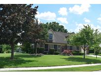 Beautiful brick home with well-manicured lawn, mature trees, and vibrant landscaping, offering great curb appeal at 1065 Lakewood South Dr, Brownsburg, IN 46112