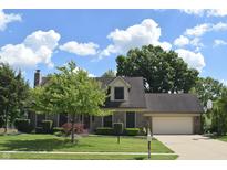Well-maintained two-story home with lush lawn, mature trees, brick facade, attached garage and basketball hoop at 1065 Lakewood South Dr, Brownsburg, IN 46112