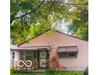 Charming one-story house with mature trees and awning covered porch and windows at 1143 Sharon Ave, Indianapolis, IN 46222