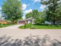 Charming single-story home with well-maintained lawn, beautiful landscaping and a two car garage at 1325 Countryside Ln, Indianapolis, IN 46231