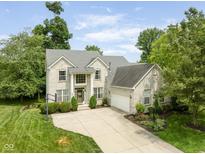 Beautiful two-story home featuring a brick facade, attached garage, and well-manicured landscaping on a sunny day at 13861 Barberry Ct, Carmel, IN 46033