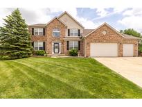 Charming brick two-story home with a well-manicured lawn and three-car garage at 2096 Whitetail Ct, Avon, IN 46123