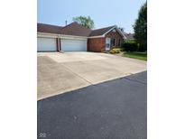 Charming brick home featuring an attached two-car garage and a paved driveway at 247 Meridian Ct, Pittsboro, IN 46167