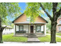 Charming two-story home with a welcoming front porch and inviting curb appeal with mature trees at 31 S Hinman St, Columbus, IN 47201