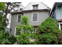 Two-story home with gray siding, white trim, and mature trees at 340 W 11Th St, Anderson, IN 46016