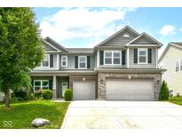 Charming two-story home featuring a well-manicured lawn and a two-car garage with an appealing stone and brick facade at 4650 Blue Marlin Way, Indianapolis, IN 46239