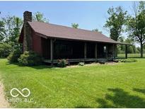 Inviting exterior of a cozy cabin featuring a full front porch and well-manicured lawn at 622 S Washington St, Morristown, IN 46161