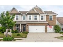 Charming two-story home with a well-manicured lawn and a two-car garage at 6296 Sugar Maple Dr, Zionsville, IN 46077