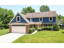 Charming two-story home showcasing a well-manicured lawn, brick accents and an attached two-car garage at 6580 Kings Ct, Avon, IN 46123