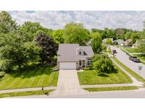 Charming two-story home with a well-manicured lawn and a lovely tree-lined street at 7402 Northfield Blvd, Fishers, IN 46038