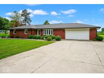 Charming single-story brick home with a well-maintained lawn and a spacious two-car garage at 7447 S 25 E, Pendleton, IN 46064