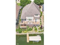 Stunning aerial view of waterfront home featuring multiple decks, boat dock and lush landscaping at 11244 Blackwalnut Pt, Indianapolis, IN 46236