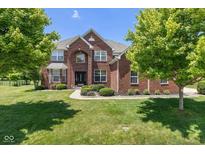 Stunning two-story brick home featuring a well-manicured lawn and professional landscaping at 12772 Tram Ln, Carmel, IN 46032