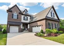 Beautiful two-story brick home featuring a three-car garage and manicured landscaping at 1521 Avondale Dr, Westfield, IN 46074