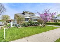 Charming single-Gathering home featuring a well-manicured lawn, sidewalk, and mature landscaping on a sunny day at 1641 Winton Ave, Speedway, IN 46224