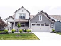 Beautiful two-story home with a white garage door, lush lawn and a welcoming front porch at 19800 Sutton Ter, Westfield, IN 46074