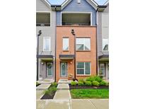 Charming townhome boasts red brick facade, modern design, inviting curb appeal, and balcony at 2125 Coretta Way, Indianapolis, IN 46202