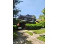 Charming two-story brick home with lush landscaping and a private driveway, offering classic curb appeal at 3702 N Delaware St, Indianapolis, IN 46205