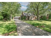 Charming two-story brick home featuring a long driveway and mature trees at 5315 Camden St, Indianapolis, IN 46227