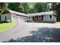 Charming home featuring stone accents, red siding, attached two-car garage, and a circular driveway at 5654 Paradise Dr, Martinsville, IN 46151
