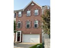 Charming brick townhome featuring dark shutters, a white garage door, and a welcoming front entrance at 6927 Havenmoor Pl, Indianapolis, IN 46250