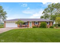 Charming brick home featuring a well-manicured lawn and inviting front porch seating area at 762 N Dellasburg Rd, Columbus, IN 47203