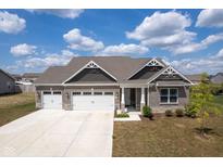 Beautiful brick home featuring a three-car garage, landscaped yard, and a charming covered porch at 7834 Fairwood Blvd, Plainfield, IN 46168