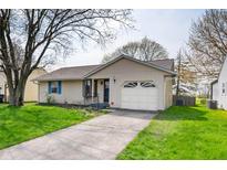 Charming single-story home featuring an attached garage, well-maintained lawn and inviting curb appeal at 829 Meadow Ln, Greenfield, IN 46140