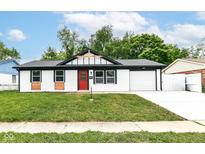 Charming single-story home with a freshly manicured lawn and a bright red front door at 8445 Montery Rd, Indianapolis, IN 46226